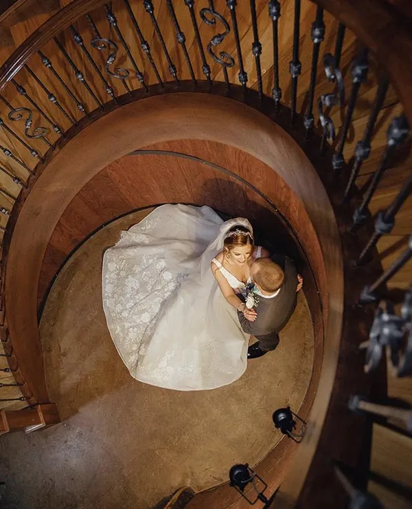 A bride and groom in the spiral staircase at Creek's Edge Winery.