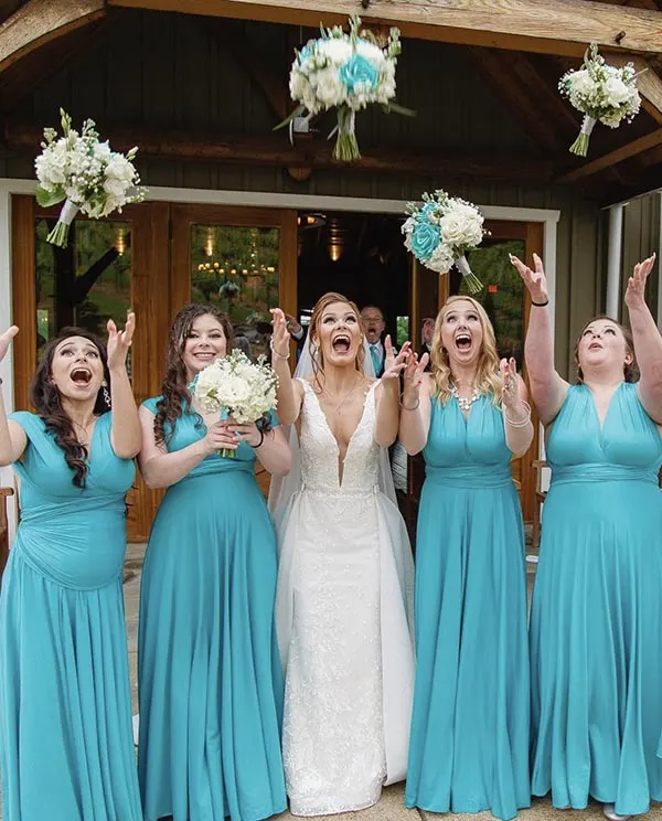 A bride and her bridesmaid throwing their bouquets at Creek's Edge Winery.